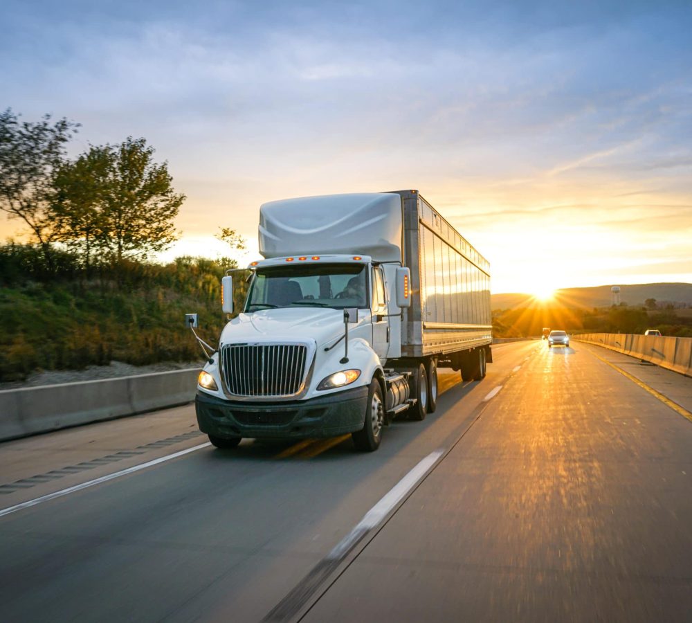 White semi-truck on the highway delivering freight